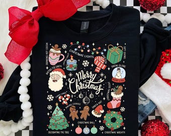 Könnte beinhalten: Schwarzes Sweatshirt mit festlichem Weihnachtsdesign. Die Grafik zeigt einen Weihnachtsbaum, den Weihnachtsmann, Lebkuchenmänner und die Worte "Merry Christmas". Das Design zeigt auch Lichterketten, Ornamente und andere festliche Elemente. Ein großer roter Bogen und rote Kugeln im Hintergrund.