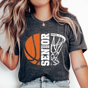 May include: A gray t-shirt with a white basketball and basketball hoop graphic. The graphic says "Senior 2026".