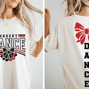 May include: White t-shirt with black text that says "MASCOT DANCE" and a black and red bow on the front. The back of the shirt has a red bow and black text that says "DANCE" vertically.