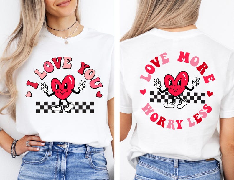 May include: White t-shirt featuring a cartoon heart with arms and legs, peace signs, and the words "I Love You" in pink and red. The design includes a black and white checkered pattern at the bottom. The back of the shirt says "Love More Worry Less".