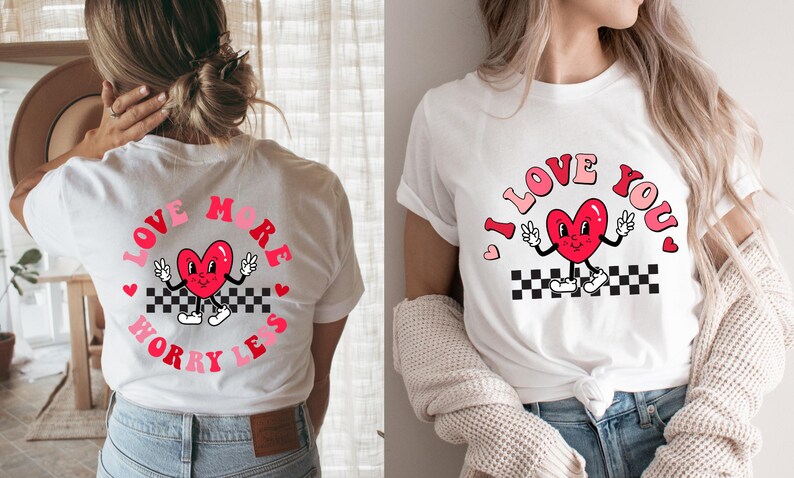 May include: White t-shirts with a retro design featuring a red heart character with peace signs. One shirt says "Love More Worry Less" in a circle, the other says "I Love You". Both have a black and white checkered pattern.