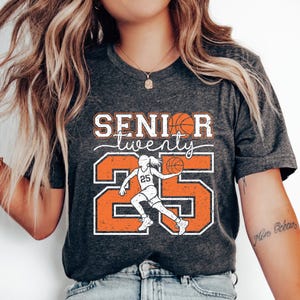May include: A gray t-shirt with the text "Senior twenty" and a basketball player graphic. The number 25 is in orange with white outlines.
