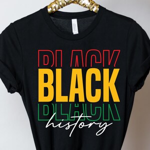 May include: Black t-shirt with the text "Black History" in yellow, red, green, and white lettering.