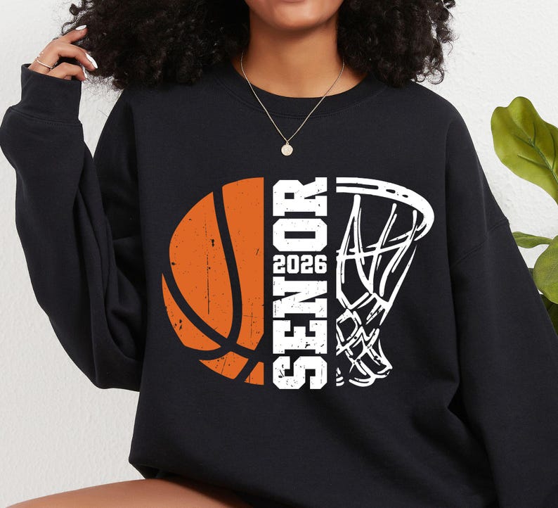 May include: Black sweatshirt with a white basketball and hoop graphic. The basketball is orange and has a distressed look. The text "Senior 2026" is printed vertically on the sweatshirt.