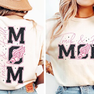 May include: A white t-shirt with a pink glitter design that says "Track & Field Mom" with a pink running shoe graphic. The back of the shirt says "Mom" with a pink running shoe graphic.