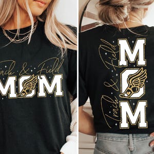 May include: Black t-shirt with gold glitter text that reads "Track & Field Mom" with a gold glitter running shoe graphic. The back of the shirt has the same text and graphic vertically.