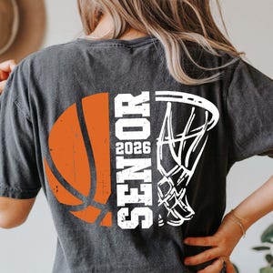 May include: A black t-shirt with a white basketball and hoop graphic. The text "Senior 2026" is printed vertically on the shirt.