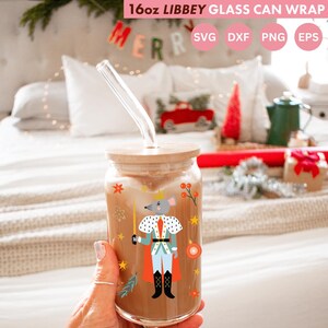 Puede incluir: Un vaso Libbey transparente de 16 oz con tapa de madera y pajita de cristal. El vaso está decorado con una ilustración de dibujos animados de un rey ratón con capa roja y traje azul. El texto "16oz LIBBEY GLASS CAN WRAP" está en la parte superior.
