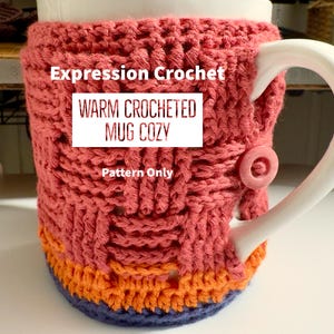 May include: A crocheted mug cosy in shades of pink, orange, and blue. The cosy is made with a textured stitch pattern and features the text "Expression Crochet Warm Crocheted Mug Cosy Pattern Only".