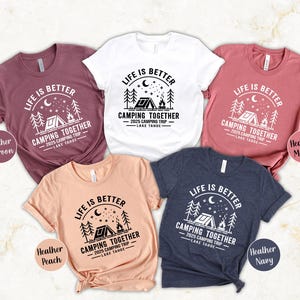 May include: A collection of five short-sleeved t-shirts in various colors, each featuring a camping-themed graphic. The design includes the text "LIFE IS BETTER CAMPING TOGETHER 2025 CAMPING TRIP LAKE TAHOE."