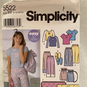 Puede incluir: Patrón de costura Simplicity número 5522 para tallas 8 1/2 a 16 1/2. El patrón incluye instrucciones para hacer pijamas, una camisa de dormir, un saco de dormir y una bolsa de mano. El patrón presenta a una niña usando pijamas y una bolsa de mano. El patrón también incluye muestras de tela para las diferentes piezas.