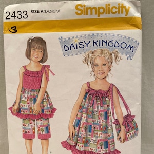Op de afbeelding: Simplicity naaipatroon nummer 2433 voor een Daisy Kingdom jurk en shorts set. Het patroon bevat instructies voor maten 3-8. Het patroon toont een jong meisje dat een roze en witte bloemenjurk draagt met een gerimpelde zoom en een bijpassend paar shorts.