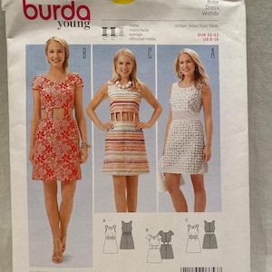 May include: Burda Young sewing pattern number 6653 for a dress. The pattern includes three different styles: a white dress with a textured surface, a striped dress with a cut-out detail, and a floral print dress. The pattern includes seam and hem allowances.