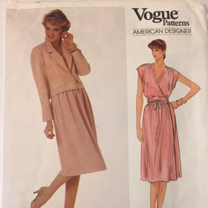 Può includere: Un modello di cucito vintage Vogue Patterns per un abito e una giacca. Il modello è per un abito rosa con un corpetto stile avvolgente e una giacca rosa abbinata. Il modello è di Adele Simpson e il numero del modello è 2920.