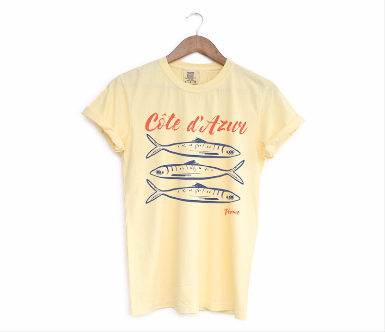 Butter Yellow T-shirt with the text Côtes d'Azur, France.

Côtes d'Azur France T-Shirt, Old Money Aesthetic, 3 Fish , French Riviera, Heritage, Sardines TShirt, France Travel Tee, Coastal Aesthetic, Retro Graphic Tee, French Vacation, Mediterranean