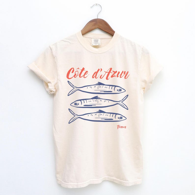 Ivory Beige T-shirt with the text Côtes d'Azur, France.

Côtes d'Azur France T-Shirt, Old Money Aesthetic, 3 Fish , French Riviera, Heritage, Sardines TShirt, France Travel Tee, Coastal Aesthetic, Retro Graphic Tee, French Vacation, Mediterranean