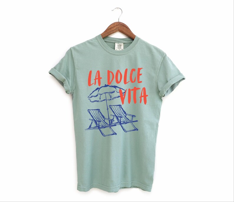 Bay Green Tee with the text LA DOLCE VITA across the chest.
Two sun chairs. One umbrella. Zero worries. Italy -where the espresso hits hard, the gelato never melts, and responsibility? Never heard of her.
Endless summer, featuring a dreamy graphic of striped beach bliss. Perfect for sun-chasers, rule-breakers, and anyone who believes naps are a lifestyle.
La Dolce Vita shirt, Tomato Girl summer, Limoncello, spaghetti vibes. Retro foodie, Portofino, Amalfi Coast Shirt, Sardines Tee