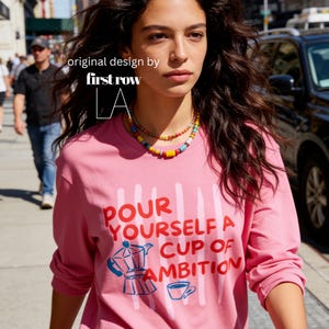 Woman wearing Dolly Parton Pour Yourself a Cup of Ambition Shirt, Retro Coffee T, 9 to 5 Country Music Tee, Moka Pot, Coffee Club, Long Sleeve T-Shirt.

Original design and copyright by first row LA 2025.