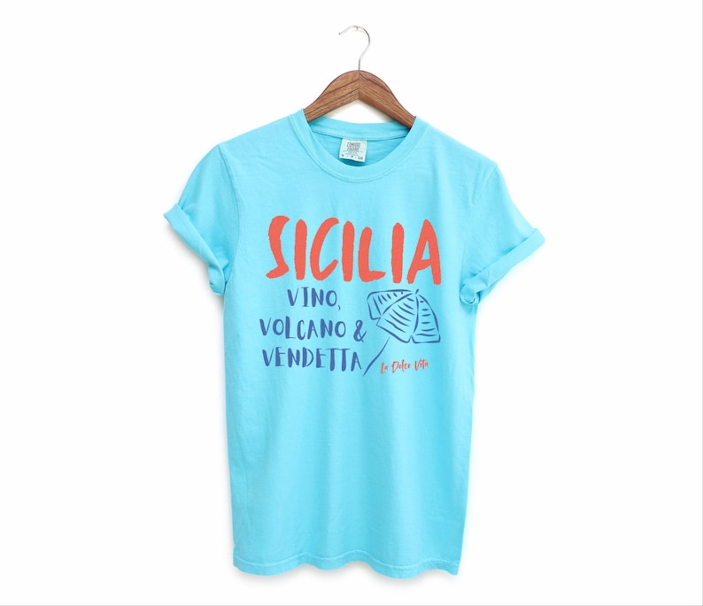 Lagoon Blue T-shirt with the text Sicilia, Vino, Volcano and Vendetta, La Dolce Vita. 

A wearable love letter to the drama, beauty, and indulgence of Sicilian culture.

Great for wine lovers, pasta enthusiasts, spontaneous adventurers, and anyone who knows that revenge is a dish best served... with a glass of Nero d’Avola.
Wear it to your next pizza night, wine tasting, or while planning your escape to the Amalfi Coast.
