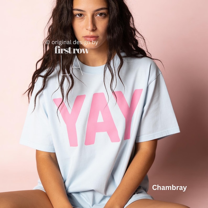Woman wearing YAY T-Shirt, Happy Pink Graphic Tee, Cute Positive Shirt, Feel Good Tee, Fun Handwritten Statement Shirt, Dopamine shirt.

Original design and copyright by first row LA 2026.