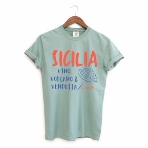 Bay Green. T-shirt with the text Sicilia, Vino, Volcano and Vendetta, La Dolce Vita. 

A wearable love letter to the drama, beauty, and indulgence of Sicilian culture.

Great for wine lovers, pasta enthusiasts, spontaneous adventurers, and anyone who knows that revenge is a dish best served... with a glass of Nero d’Avola.
Wear it to your next pizza night, wine tasting, or while planning your escape to the Amalfi Coast.