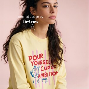 Woman wearing Dolly Parton Pour Yourself a Cup of Ambition Shirt, Retro Coffee T, 9 to 5 Country Music Tee, Moka Pot, Coffee Club, Long Sleeve T-Shirt.

Original design and copyright by first row LA 2025.