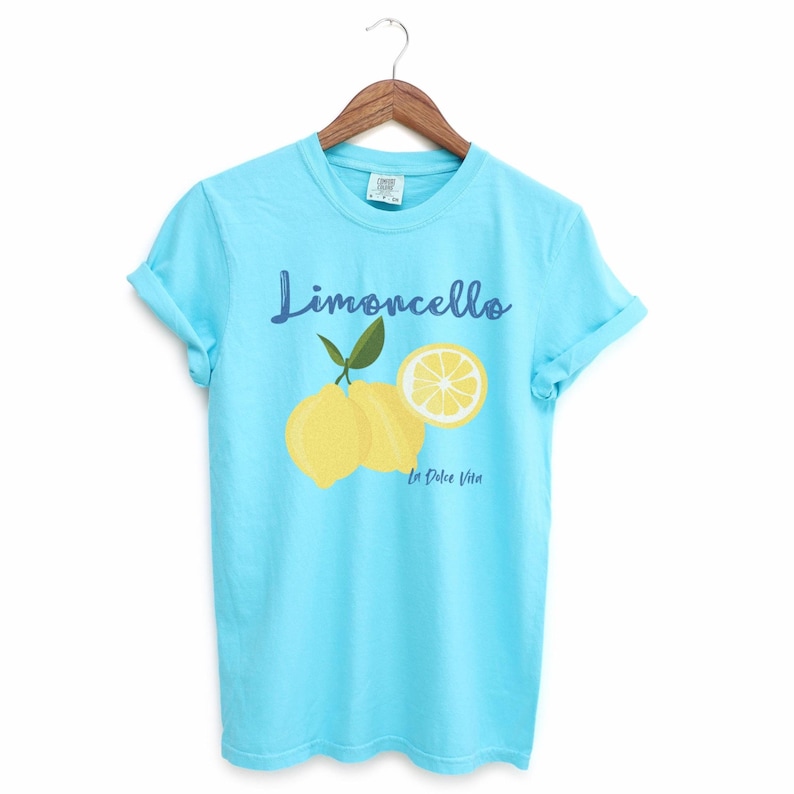 Lagoon Blue T-shirt with the text Limoncello, La Dolce Vita, follewed by a juicy lemon graphics.
Limoncello Shirt, La Dolce Vita Tee, Lemon Shirt, Amalfi Coast, Italy TShirt, Vacay T-Shirt, Lemons Tee, Cocktail T Shirt, Retro Graphic Tee
