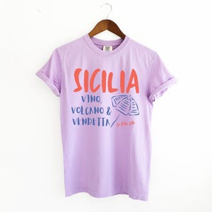 Orchid Purple T-shirt with the text Sicilia, Vino, Volcano and Vendetta, La Dolce Vita. 

A wearable love letter to the drama, beauty, and indulgence of Sicilian culture.

Great for wine lovers, pasta enthusiasts, spontaneous adventurers, and anyone who knows that revenge is a dish best served... with a glass of Nero d’Avola.
Wear it to your next pizza night, wine tasting, or while planning your escape to the Amalfi Coast.