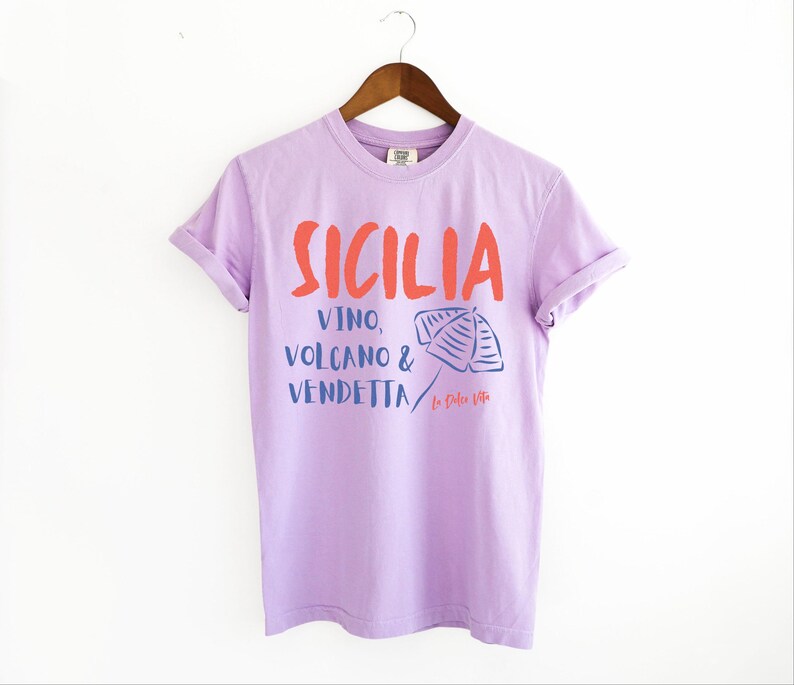Orchid Purple T-shirt with the text Sicilia, Vino, Volcano and Vendetta, La Dolce Vita. 

A wearable love letter to the drama, beauty, and indulgence of Sicilian culture.

Great for wine lovers, pasta enthusiasts, spontaneous adventurers, and anyone who knows that revenge is a dish best served... with a glass of Nero d’Avola.
Wear it to your next pizza night, wine tasting, or while planning your escape to the Amalfi Coast.
