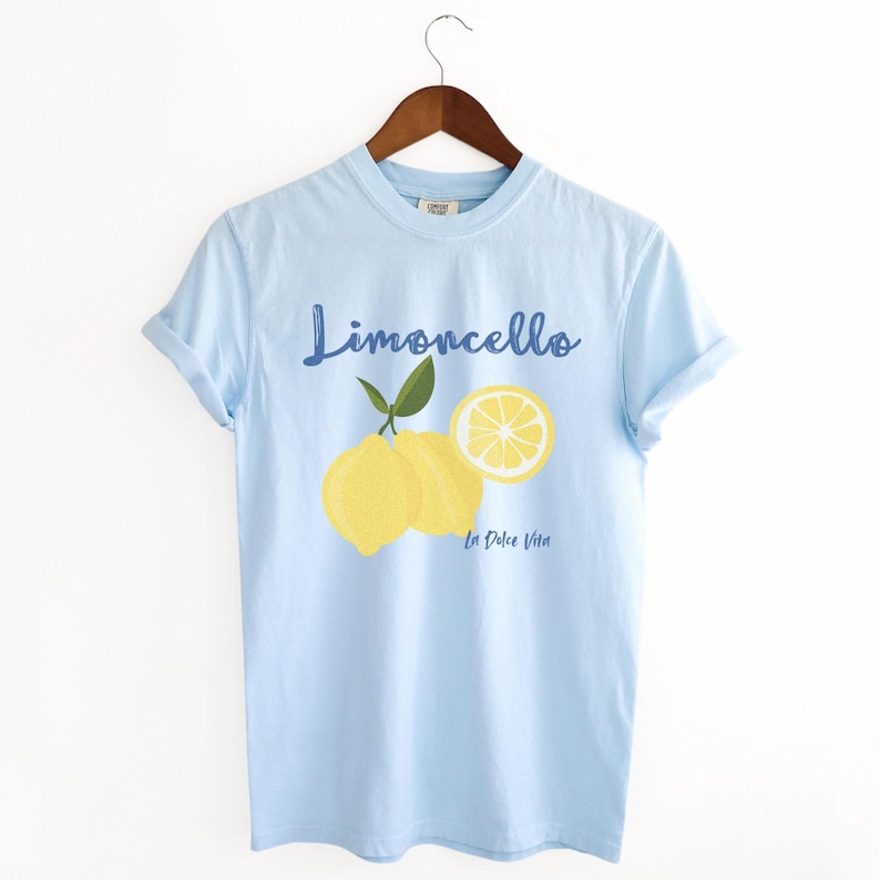 Chambray Light Blue T-shirt with the text Limoncello, La Dolce Vita, follewed by a juicy lemon graphics.
Limoncello Shirt, La Dolce Vita Tee, Lemon Shirt, Amalfi Coast, Italy TShirt, Vacay T-Shirt, Lemons Tee, Cocktail T Shirt, Retro Graphic Tee