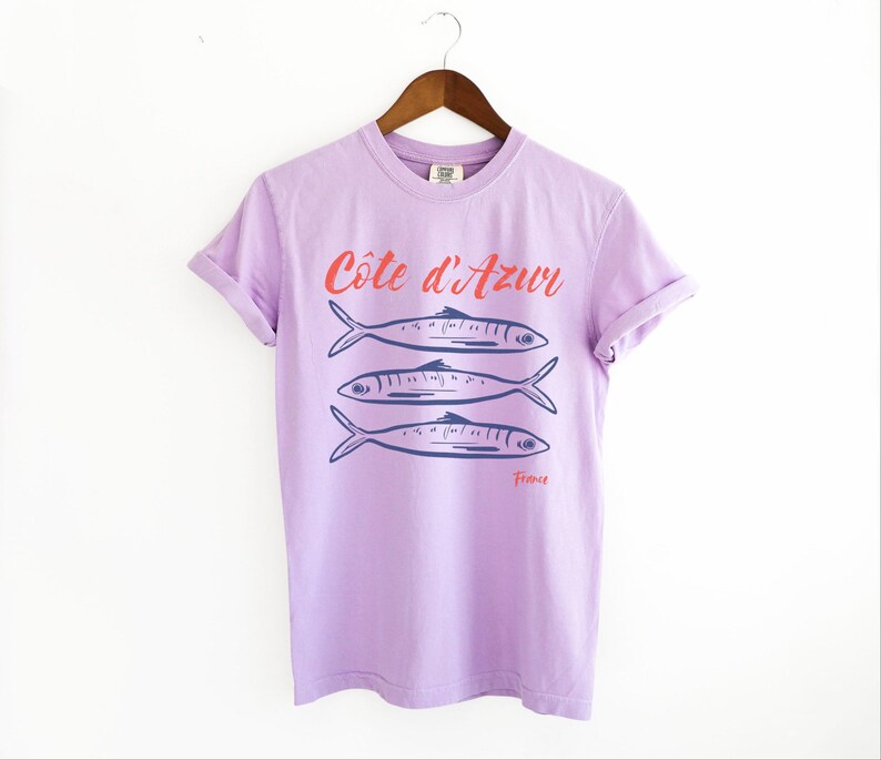 Orchid Purple T-shirt with the text Côtes d'Azur, France.

Côtes d'Azur France T-Shirt, Old Money Aesthetic, 3 Fish , French Riviera, Heritage, Sardines TShirt, France Travel Tee, Coastal Aesthetic, Retro Graphic Tee, French Vacation, Mediterranean