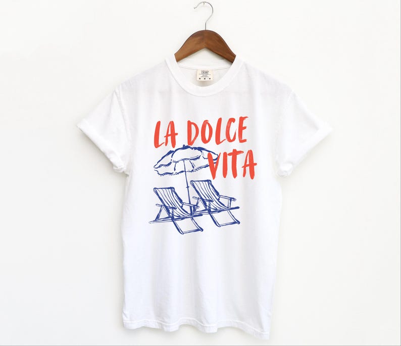 White tee with the text LA DOLCE VITA across the chest.
Two sun chairs. One umbrella. Zero worries. Italy -where the espresso hits hard, the gelato never melts, and responsibility? Never heard of her.
Endless summer, featuring a dreamy graphic of striped beach bliss. Perfect for sun-chasers, rule-breakers, and anyone who believes naps are a lifestyle.
La Dolce Vita shirt, Tomato Girl summer, Limoncello, spaghetti vibes. Retro foodie, Portofino, Amalfi Coast Shirt, Sardines Tee