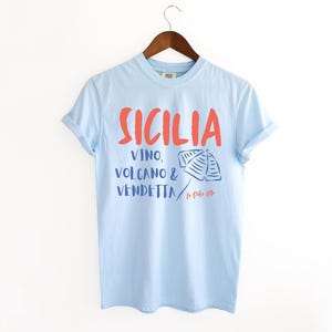 Chambray Light Blue T-shirt with the text Sicilia, Vino, Volcano and Vendetta, La Dolce Vita. 

A wearable love letter to the drama, beauty, and indulgence of Sicilian culture.

Great for wine lovers, pasta enthusiasts, spontaneous adventurers, and anyone who knows that revenge is a dish best served... with a glass of Nero d’Avola.
Wear it to your next pizza night, wine tasting, or while planning your escape to the Amalfi Coast.