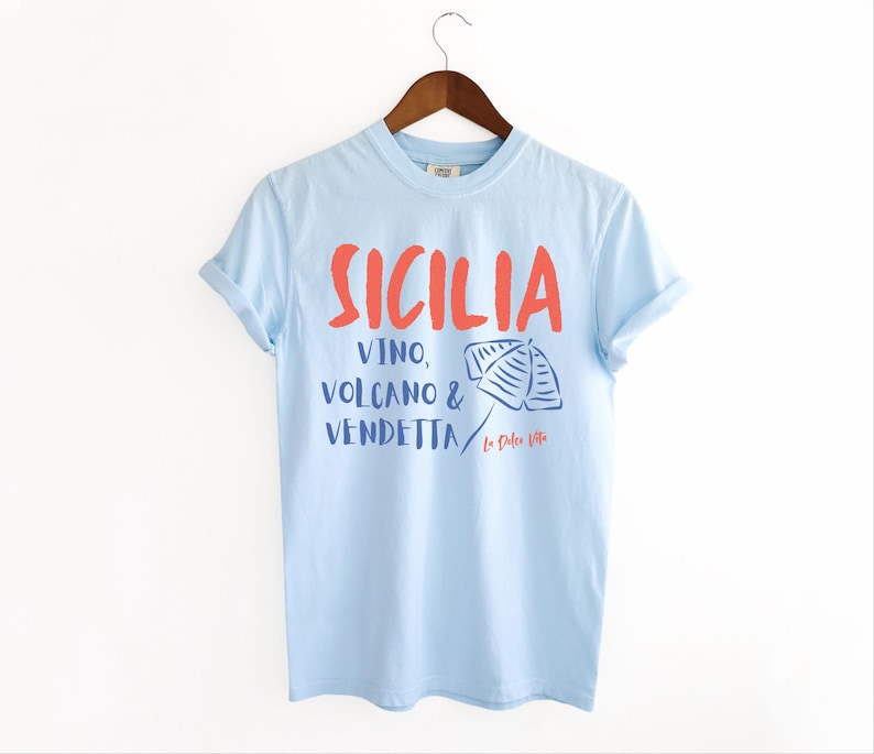 Chambray Light Blue T-shirt with the text Sicilia, Vino, Volcano and Vendetta, La Dolce Vita. 

A wearable love letter to the drama, beauty, and indulgence of Sicilian culture.

Great for wine lovers, pasta enthusiasts, spontaneous adventurers, and anyone who knows that revenge is a dish best served... with a glass of Nero d’Avola.
Wear it to your next pizza night, wine tasting, or while planning your escape to the Amalfi Coast.