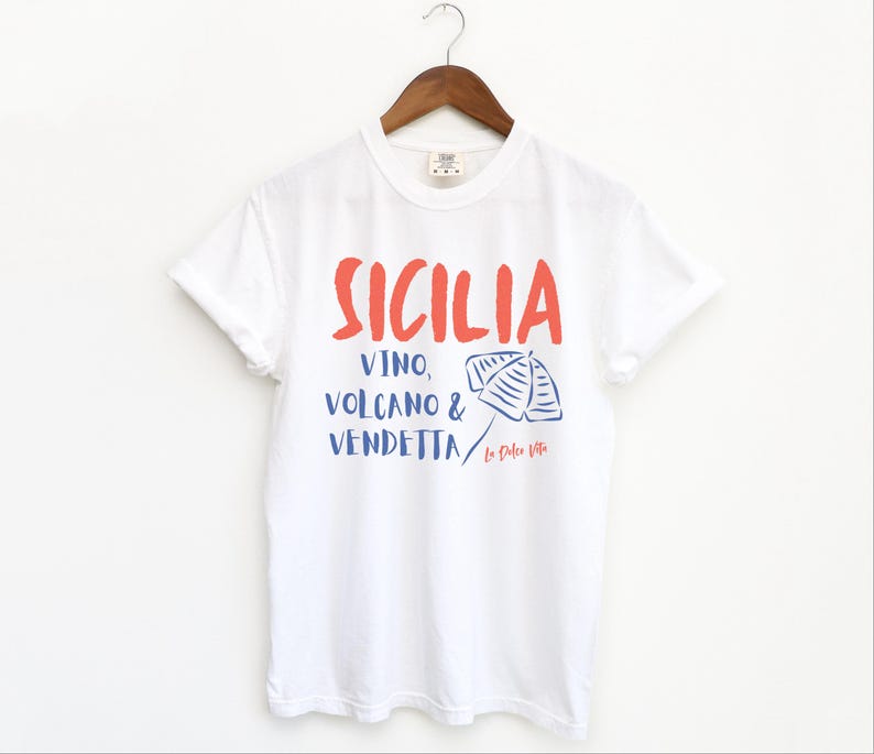 White T-shirt with the text Sicilia, Vino, Volcano and Vendetta, La Dolce Vita. 

A wearable love letter to the drama, beauty, and indulgence of Sicilian culture.

Great for wine lovers, pasta enthusiasts, spontaneous adventurers, and anyone who knows that revenge is a dish best served... with a glass of Nero d’Avola.
Wear it to your next pizza night, wine tasting, or while planning your escape to the Amalfi Coast.