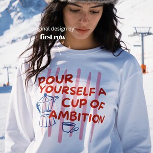 Woman wearing Dolly Parton Pour Yourself a Cup of Ambition Shirt, Retro Coffee T, 9 to 5 Country Music Tee, Moka Pot, Coffee Club, Long Sleeve T-Shirt.

Original design and copyright by first row LA 2025.