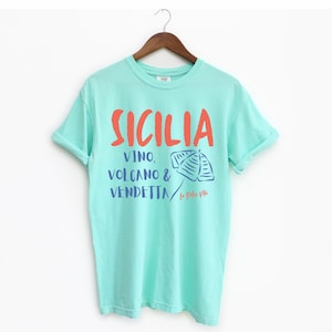 Island Reef T-shirt with the text Sicilia, Vino, Volcano and Vendetta, La Dolce Vita. 

A wearable love letter to the drama, beauty, and indulgence of Sicilian culture.

Great for wine lovers, pasta enthusiasts, spontaneous adventurers, and anyone who knows that revenge is a dish best served... with a glass of Nero d’Avola.
Wear it to your next pizza night, wine tasting, or while planning your escape to the Amalfi Coast.