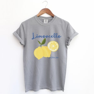 Grey T-shirt with the text Limoncello, La Dolce Vita, follewed by a juicy lemon graphics.
Limoncello Shirt, La Dolce Vita Tee, Lemon Shirt, Amalfi Coast, Italy TShirt, Vacay T-Shirt, Lemons Tee, Cocktail T Shirt, Retro Graphic Tee
