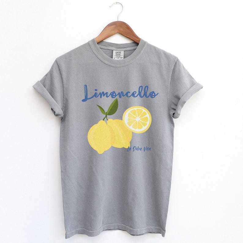 Grey T-shirt with the text Limoncello, La Dolce Vita, follewed by a juicy lemon graphics.
Limoncello Shirt, La Dolce Vita Tee, Lemon Shirt, Amalfi Coast, Italy TShirt, Vacay T-Shirt, Lemons Tee, Cocktail T Shirt, Retro Graphic Tee