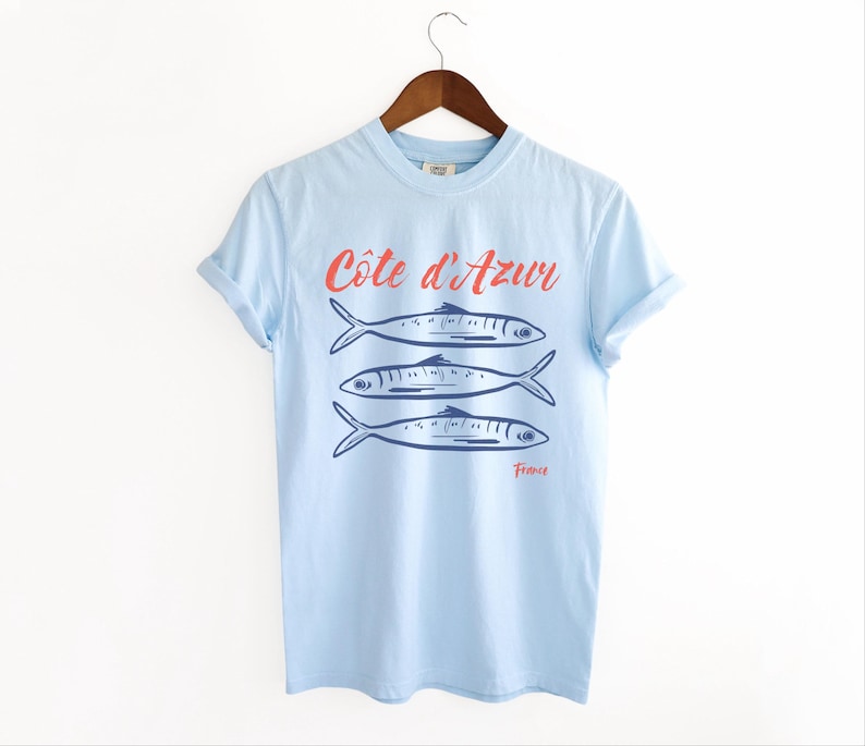 Chambray Light Blue T-shirt with the text Côtes d'Azur, France.

Côtes d'Azur France T-Shirt, Old Money Aesthetic, 3 Fish , French Riviera, Heritage, Sardines TShirt, France Travel Tee, Coastal Aesthetic, Retro Graphic Tee, French Vacation, Mediterranean