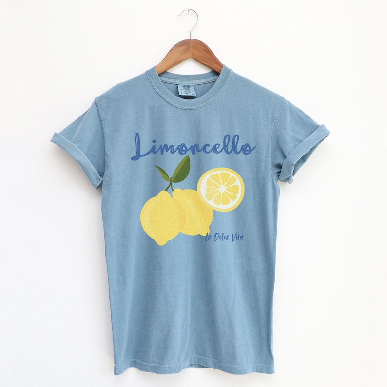 Ice Blue T-shirt with the text Limoncello, La Dolce Vita, follewed by a juicy lemon graphics.
Limoncello Shirt, La Dolce Vita Tee, Lemon Shirt, Amalfi Coast, Italy TShirt, Vacay T-Shirt, Lemons Tee, Cocktail T Shirt, Retro Graphic Tee
