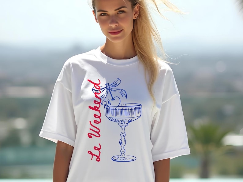 Model wearing a white T-shirt with the text Le Weekend and a Cherry Coquette Cocktail graphic.

Because what’s a good time without a little flair?

Perfect for brunch dates, rooftop soirées, or just channeling that effortlessly flirty energy. French twist, retro feel, full-on main character mood.
Weekend Shirt, Le Weekend, French T-Shirt, Weekending, Vintage Aesthetic, Coquette Bow Cherry, Cocktail Tee, y2k T-shirt, weekend vibes tee.