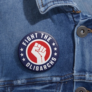 Puede incluir: Un botón azul y rojo con un puño en alto y el texto "FIGHT THE OLIGARCHS" en un círculo con cinco estrellas.