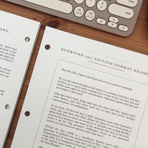 Może przedstawiać: Dwa białe arkusze papieru z czarnym tekstem, z tytułem "QUERYING 101: FICTION FORMAT EXAMPLE" i innym tekstem, znajdują się na drewnianej powierzchni. Klawiatura i mysz komputerowa znajdują się w tle.