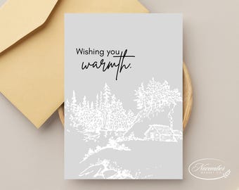 Könnte beinhalten: Eine graue Karte mit dem Text "Wishing you warmth." in schwarzer Schrift. Die Karte zeigt eine weiße Linienzeichnung einer Hütte im Wald mit Bäumen und einem Fluss.