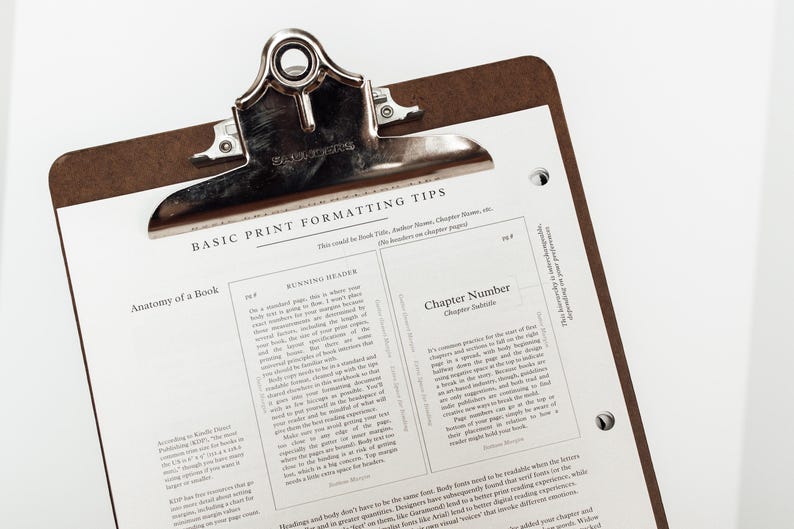 Może przedstawiać: Brązowa podkładka z metalowym klipsem trzymającym białą kartkę papieru. Papier zawiera tytuł "BASIC PRINT FORMATTING TIPS" i tekst o formatowaniu książek. Podkładka znajduje się na białym tle.