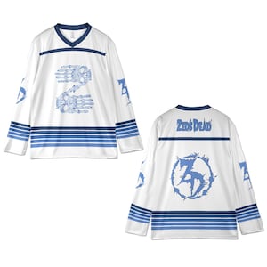May include: White hockey jersey with blue accents and long sleeves. The front features a blue skeletal hand design forming the number 2. The back displays the text "Zeds Dead" above a blue circular graphic with the number 3.