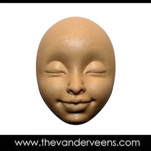 Puede incluir: Una cara de muñeca ovalada de color beige, con los ojos cerrados y una ligera sonrisa. La cara tiene una textura suave y está sobre un fondo blanco. La dirección del sitio web www.thevandeveens.com está en la parte inferior.