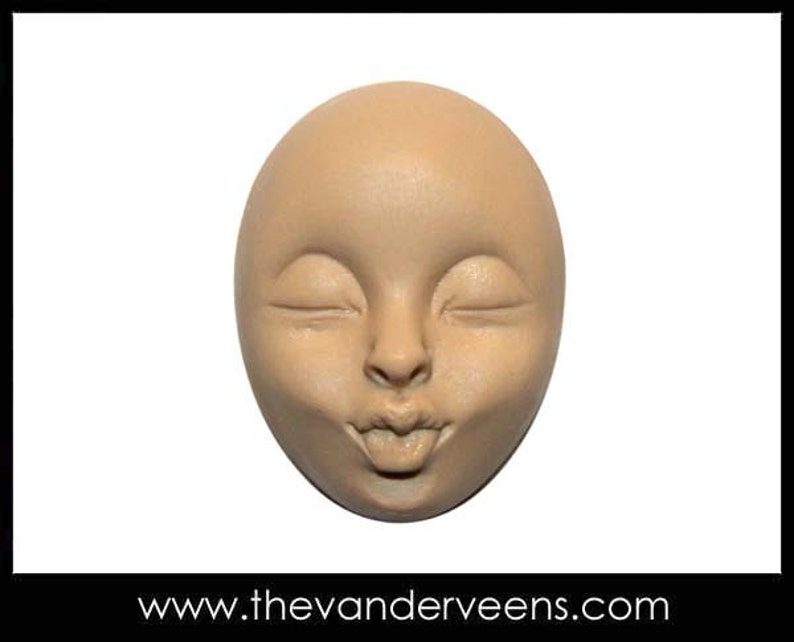 Puede incluir: Una escultura de cer&aacute;mica de un rostro con los ojos cerrados y la boca fruncida, sugiriendo un beso. La escultura es de color beige claro.