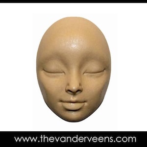 May include: A beige ceramic sculpture of a face with closed eyes. The sculpture is smooth and has a realistic appearance.